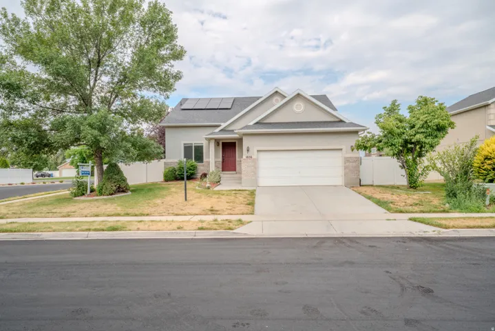 Contemporary stucco exterior with stone accents, a two-car garage, and a covered front entry