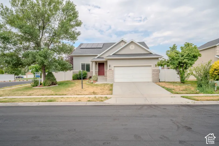 Contemporary stucco exterior with stone accents, a two-car garage, and a covered front entry