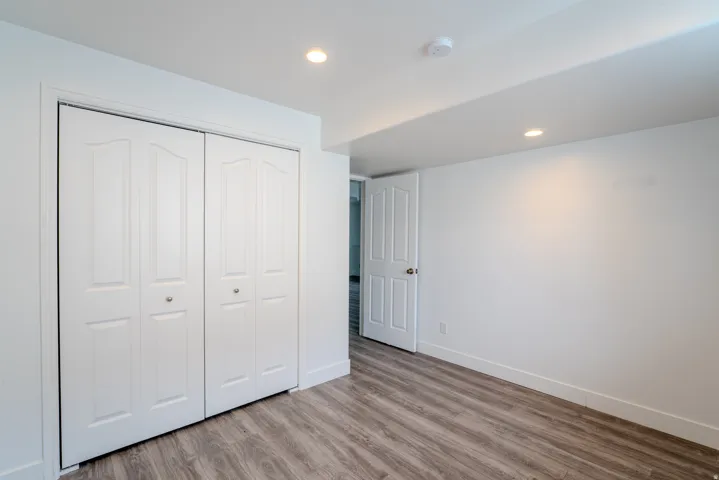 Interior room featuring wood-finish flooring, white walls, and recessed lighting