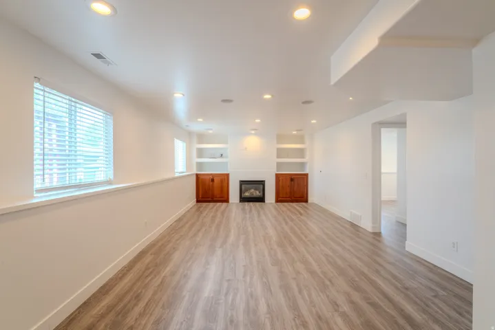 Spacious lower-level area featuring recessed lighting, light wood-finish flooring, and white walls