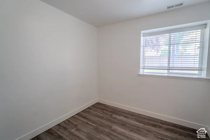 Room featuring wood-finish flooring, white baseboards, and neutral wall paint