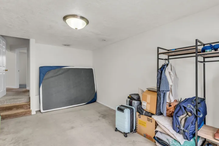 Carpeted room with a flush-mount ceiling light fixture, white walls, and a white interior door