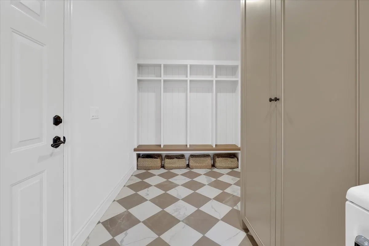 Mudroom featuring a built-in white storage system with individual cubbies and a wood bench