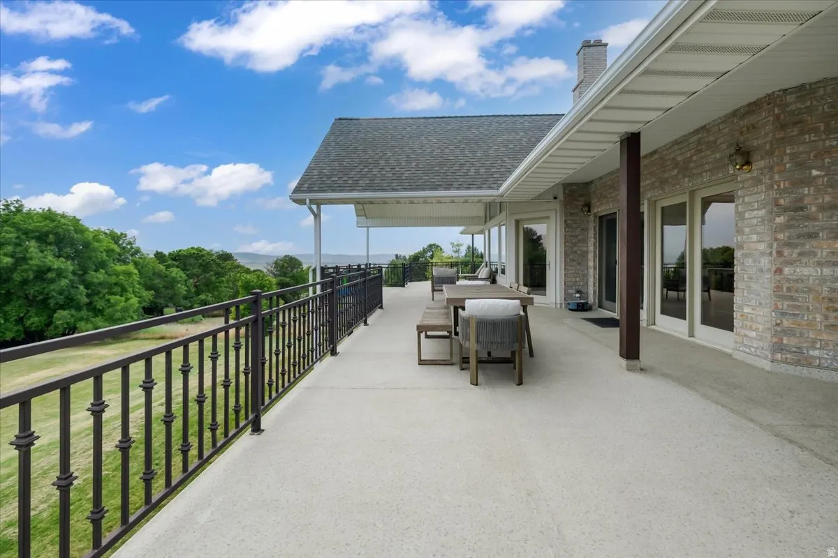 Expansive concrete deck featuring a black wrought iron railing