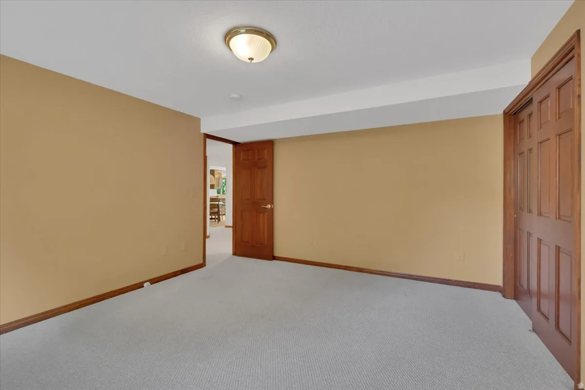 Room featuring light gray carpeting and warm-toned wall paint
