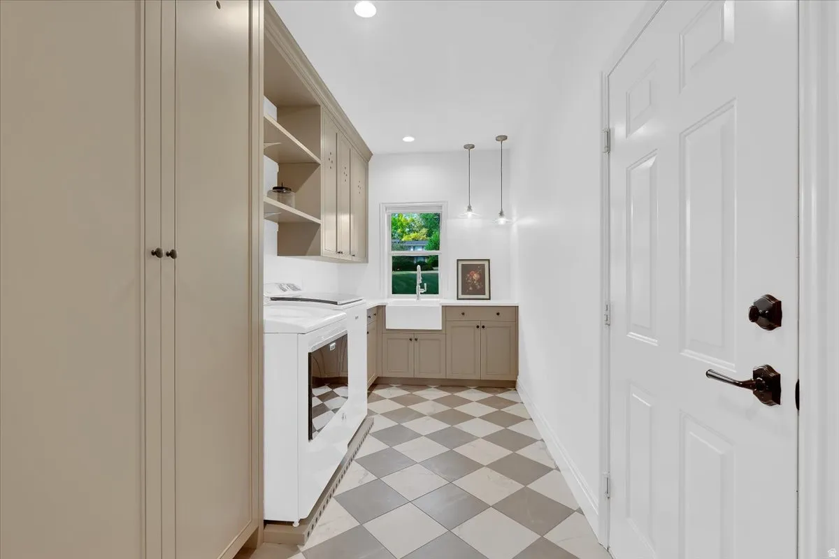 Utility room featuring checkered floor tile, recessed lighting, built-in cabinetry, a farmhouse sink, and a window providing natural light