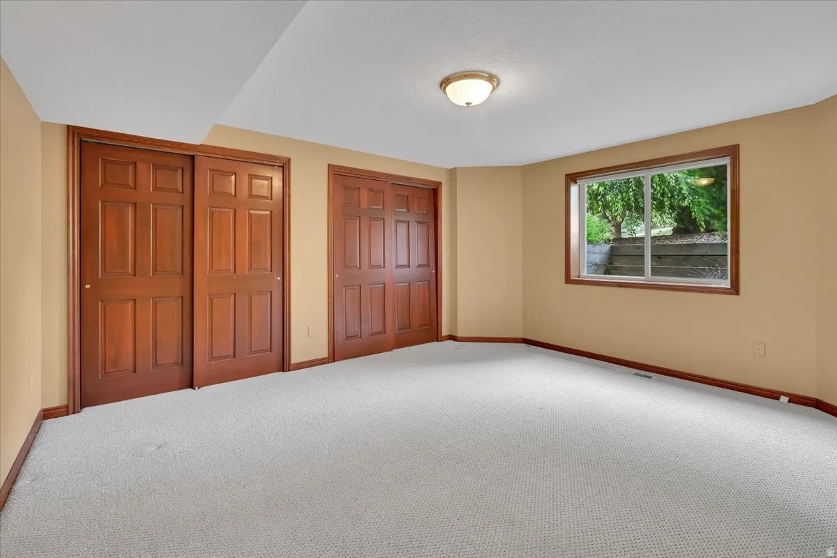 Neutral-toned room with light carpet flooring and a window offering exterior views