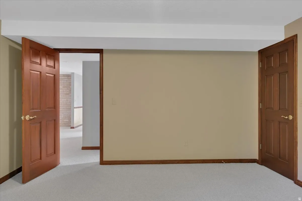 Interior room featuring light-toned carpeting and neutral wall paint