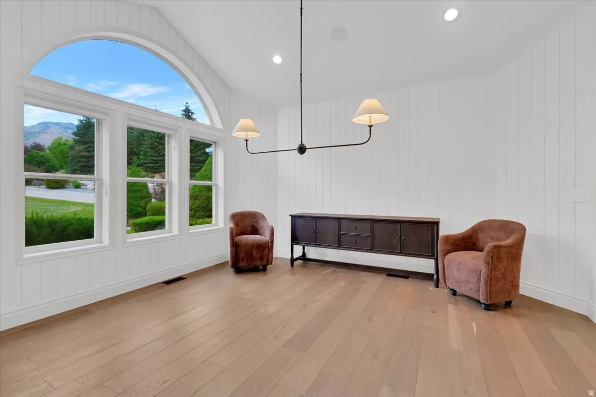 Vaulted ceiling room featuring an expansive arched window and two additional windows