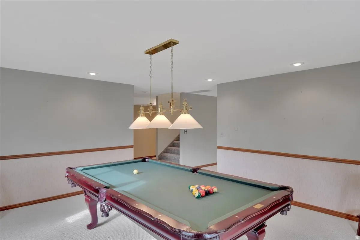 Recreation area featuring a built-in pool table, overhead brass pendant lighting, recessed ceiling lights, and wainscoting with wood trim