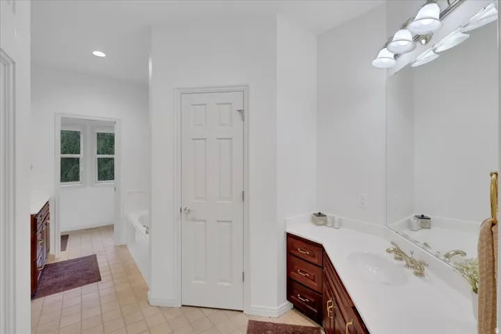 Bathroom featuring a single vanity with a white countertop, an undermount sink, and a large wall mirror