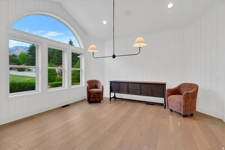 Vaulted ceiling room featuring an expansive arched window and two additional windows