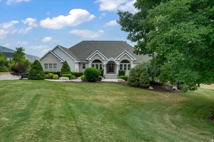Expansive front lawn with mature trees and established landscaping