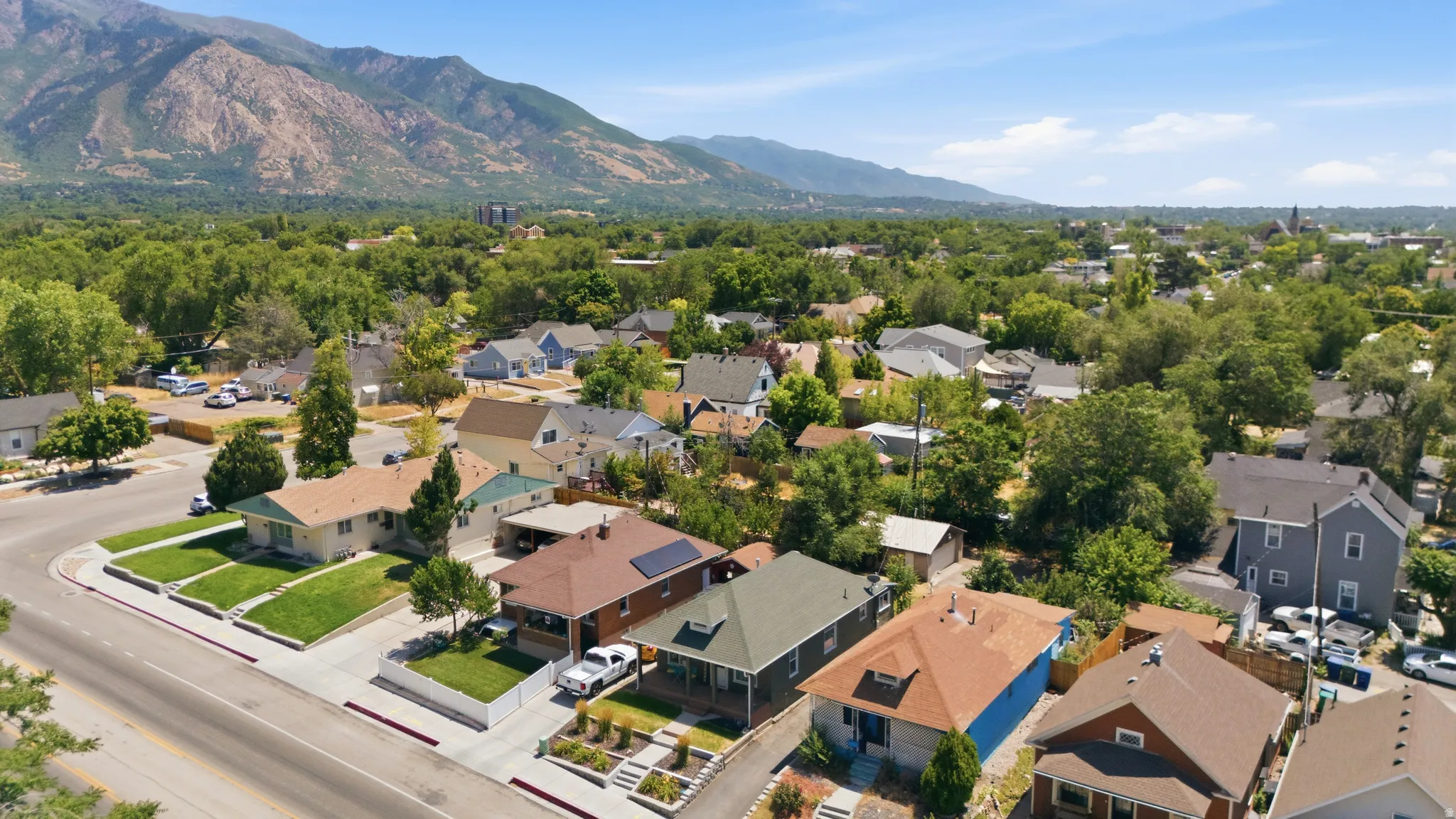 Aerial perspective showcasing a neighborhood with diverse residential architecture and verdant tree cover