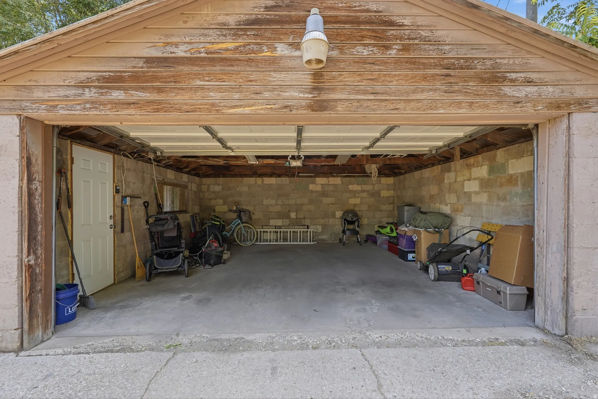 Two-car detached garage featuring concrete flooring and block wall construction