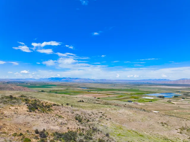Expansive land offering diverse topography, including rolling hillsides and flat cultivated areas