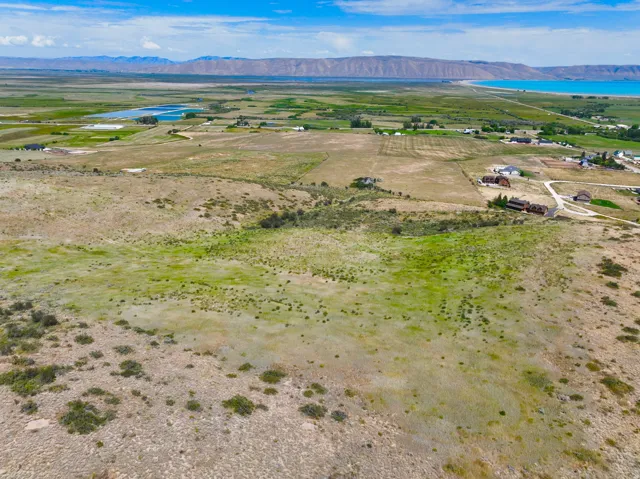 Expansive land parcel featuring natural topography, distant mountain ranges, and a visible body of water
