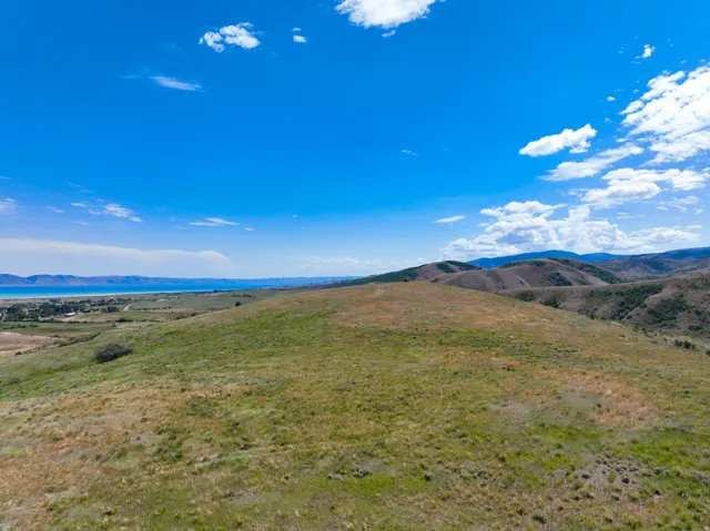 Expansive open terrain featuring natural grasses and rolling hills