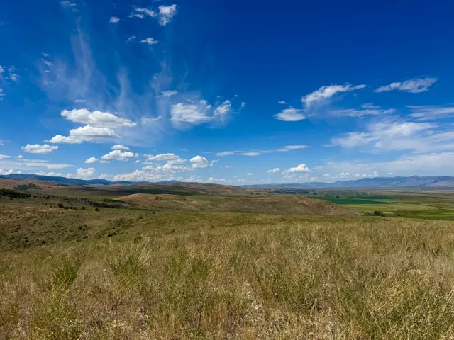 Expansive natural landscape featuring rolling hills and distant mountains
