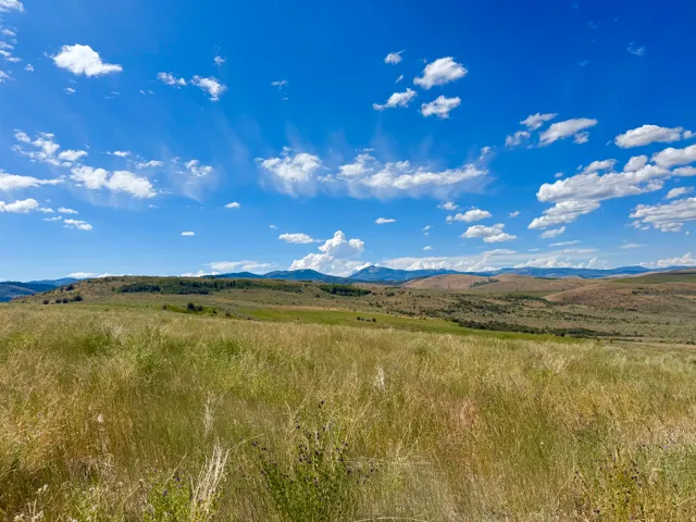 Expansive natural landscape featuring rolling hills and distant mountains