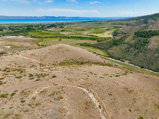 Expansive undeveloped land with a distant lake, verdant fields, and rolling hills