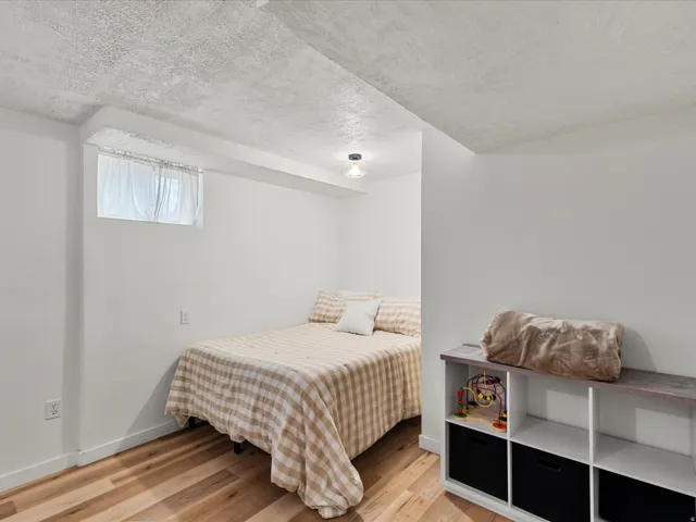 Room featuring wood-finish flooring, white walls, and a recessed window
