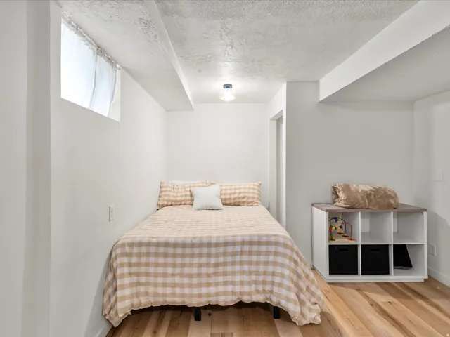 Room with wood-finish flooring, a single window opening, and a built-in ceiling light fixture