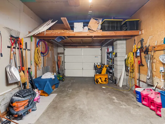Garage with concrete flooring, overhead storage, and a paneled garage door