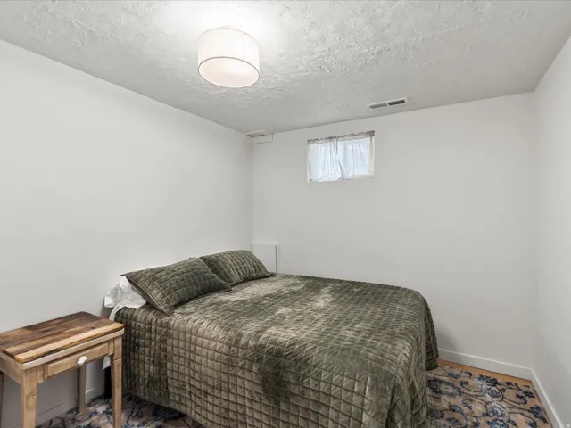 Bedroom featuring light-colored walls and a textured ceiling