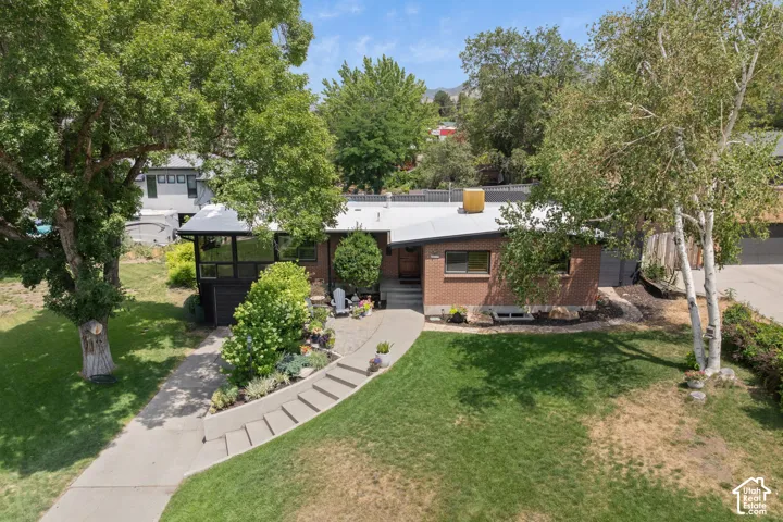 Brick exterior with a covered patio and concrete walkway
