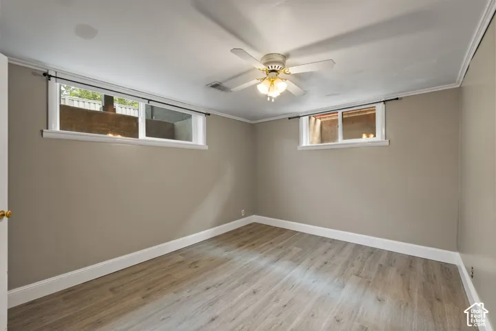 Room featuring wood-finish flooring, neutral wall paint, and white trim