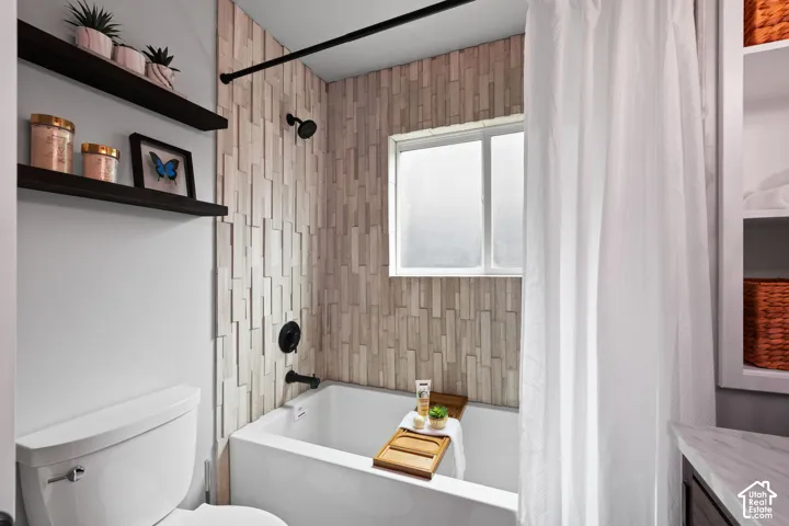 Bathroom featuring a white tub, textured wall tile, and a privacy window
