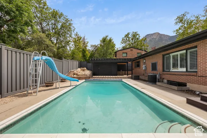 In-ground swimming pool with integrated steps, surrounded by concrete decking and a gravel perimeter