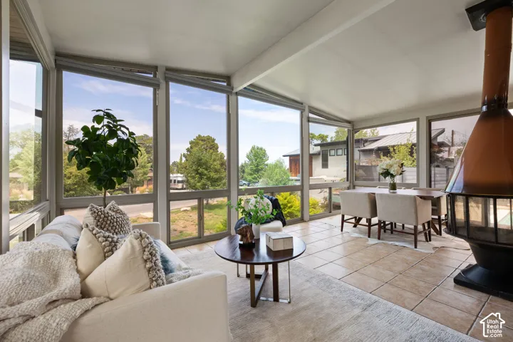 Living space featuring expansive windows, vaulted ceilings, a built-in fireplace, and tile flooring