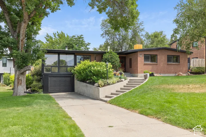 Mid-century modern residence featuring brick and dark-framed extensive windows