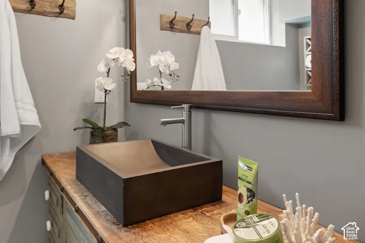 Rectangular vessel sink with a contemporary faucet, set on a distressed wood-finish countertop