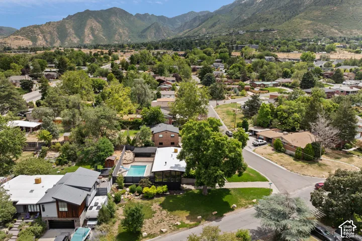 Mid-century modern residence featuring a private swimming pool, mature tree landscaping, and a multi-level roofline