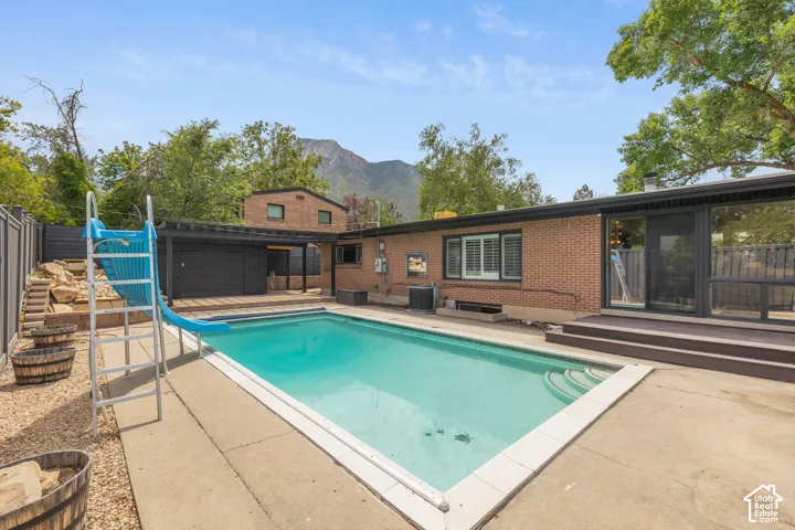 Rectangular in-ground pool with concrete surround and mountain backdrop
