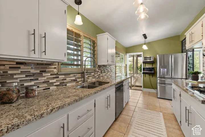 Kitchen featuring white cabinetry, light granite countertops, and a mosaic tile backsplash
