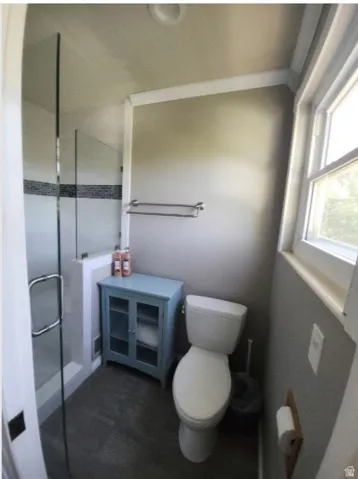 on Suite for Primar bedroom, Enclosed shower with glass panel door, featuring a tiled accent strip