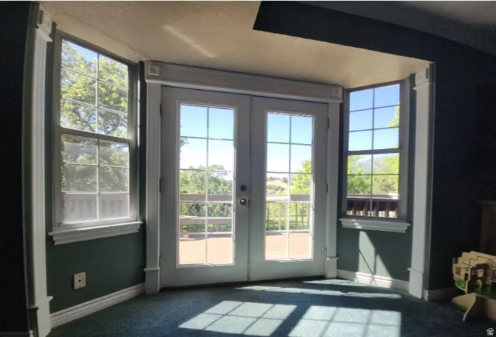 French doors opening to backyard deck, featuring the view