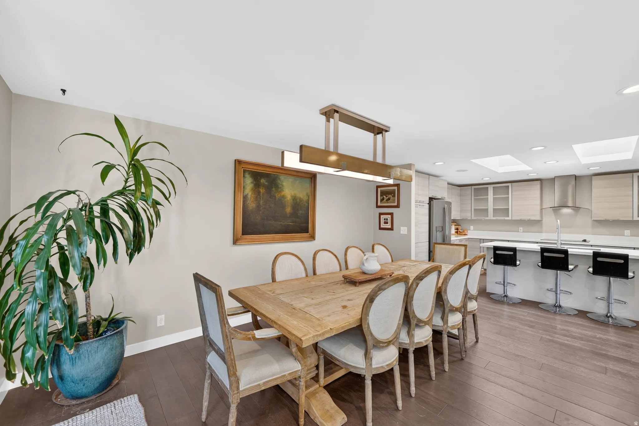 Open-concept dining area featuring wood-finish flooring and a contemporary chandelier