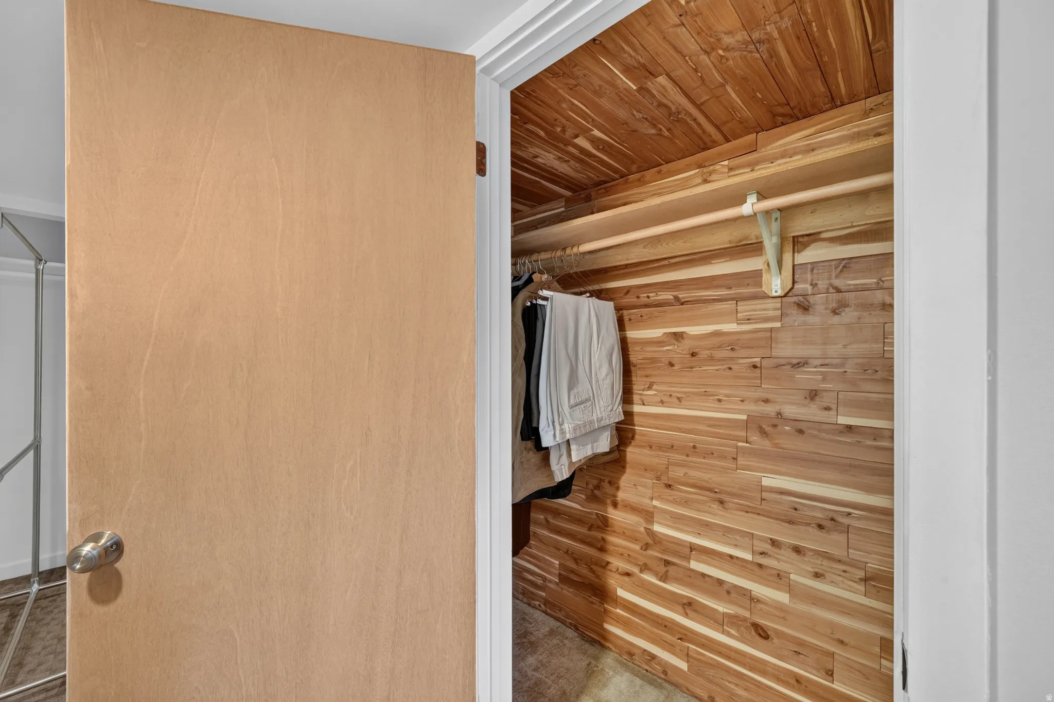 Custom closet featuring cedar plank walls and ceiling