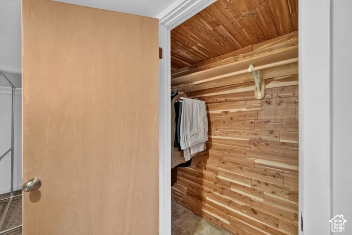 Custom closet featuring cedar plank walls and ceiling