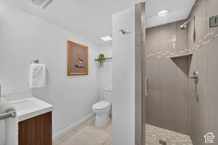 Full bathroom featuring a walk-in shower with glass enclosure, wall-mounted showerhead, and tiled walls with decorative accents