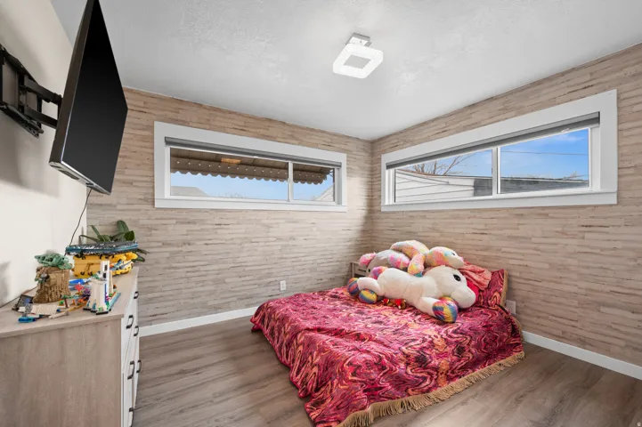 Wood-finish flooring paired with a textured accent wall