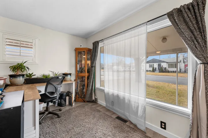 Interior room featuring a large window with sheer and blackout curtains, offering natural light