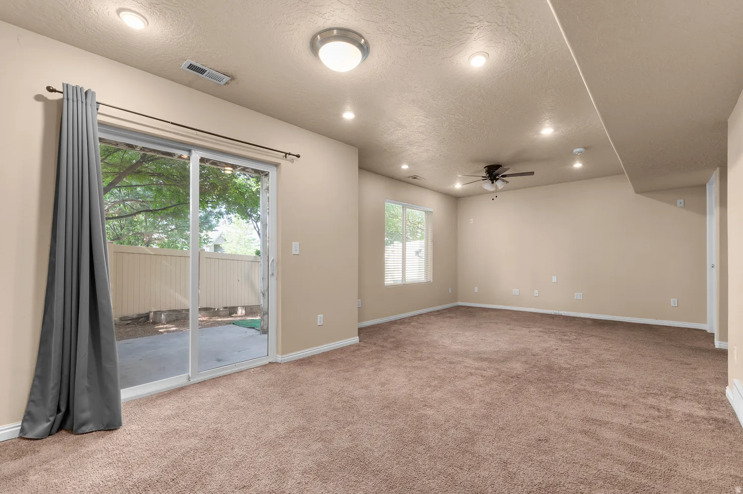 Spacious room with plush brown carpeting and neutral wall paint