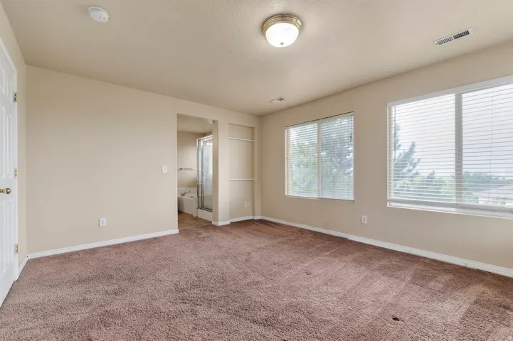 Spacious room featuring neutral-toned walls and plush carpeting