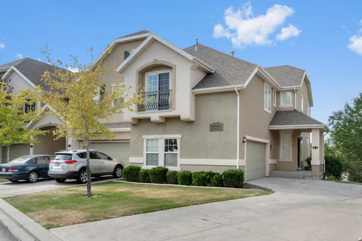 Stucco exterior with contrasting trim, featuring a covered entryway and a second-story balcony with an ornamental railing